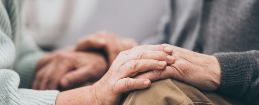 Older couple holding each other’s hands.